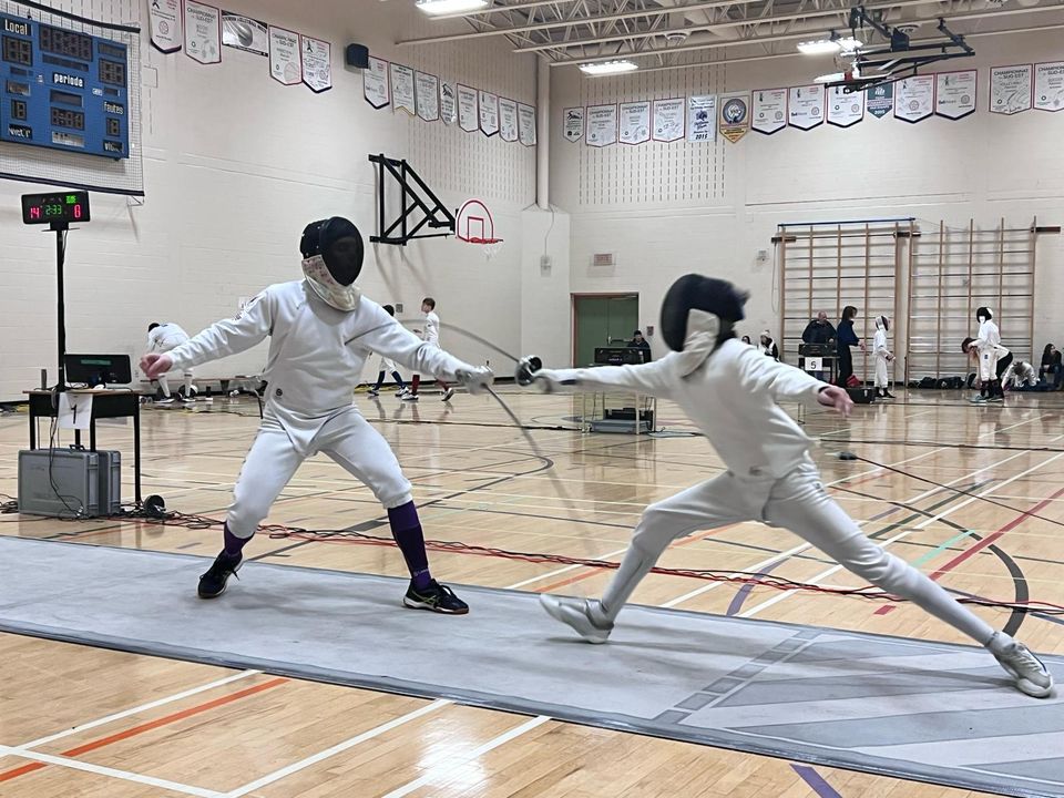 Two fencers in white uniforms bouting on a piste in a gymnasium